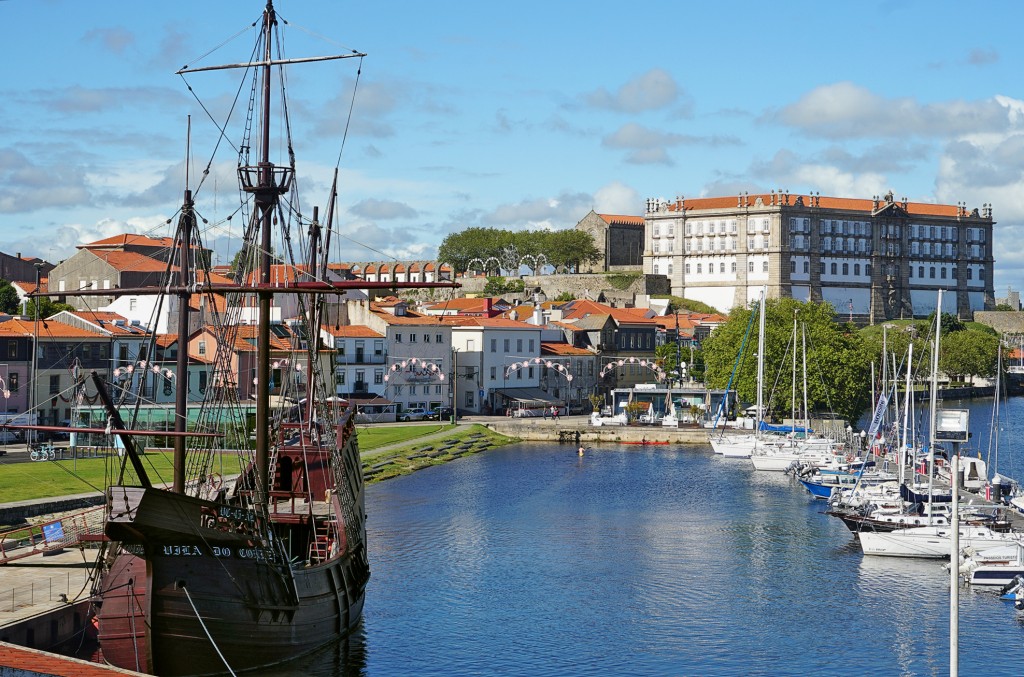 Ein historisches Schiff liegt im Hafen mit Blick auf eine Stadt und Yachten.