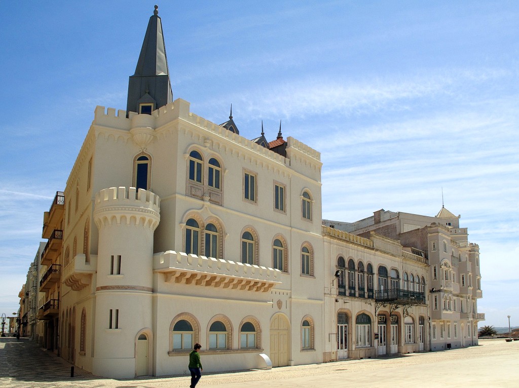 Prachtvolles, helles Gebäude mit Turm und Erkerfenstern am Strand.
