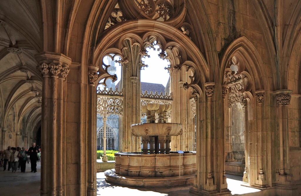 Brunnen in einem Klosterhof mit gotischer Architektur und Sonneneinfall