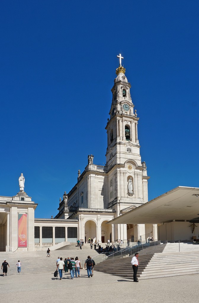 Majestätische Kirche mit hohem Glockenturm und breiter Treppe vor ihr.