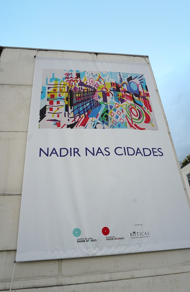 A vibrant mural depicting urban architecture adorns a building wall.