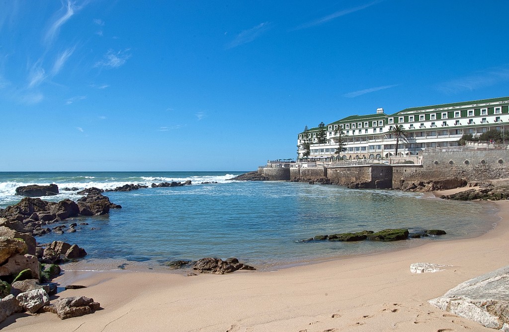Strand mit Felsen und einem Hotel im Hintergrund