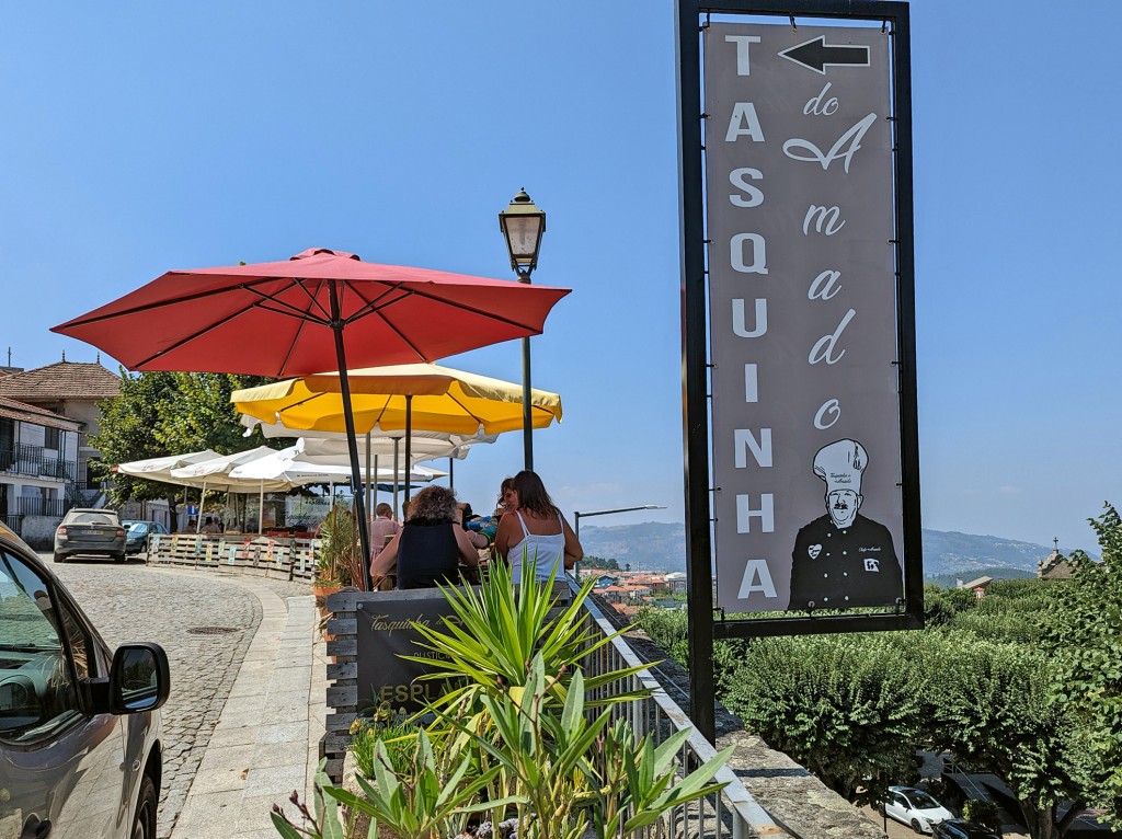 Outdoor restaurant with a view and a sign featuring a chef's portrait