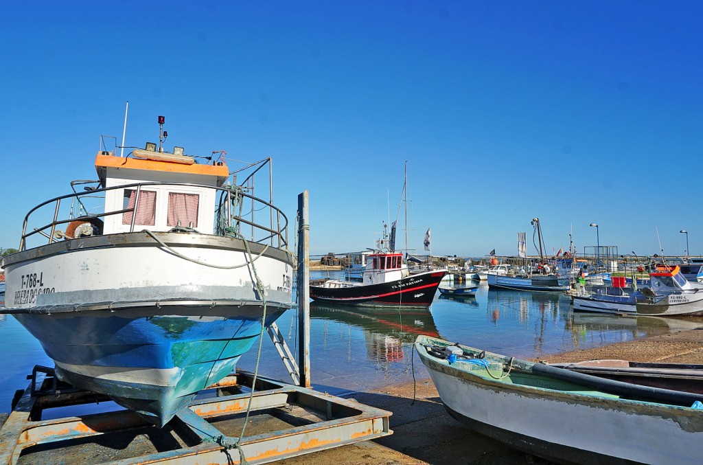 Boote liegen im Hafen mit blauem Himmel und hellem Sonnenlicht.