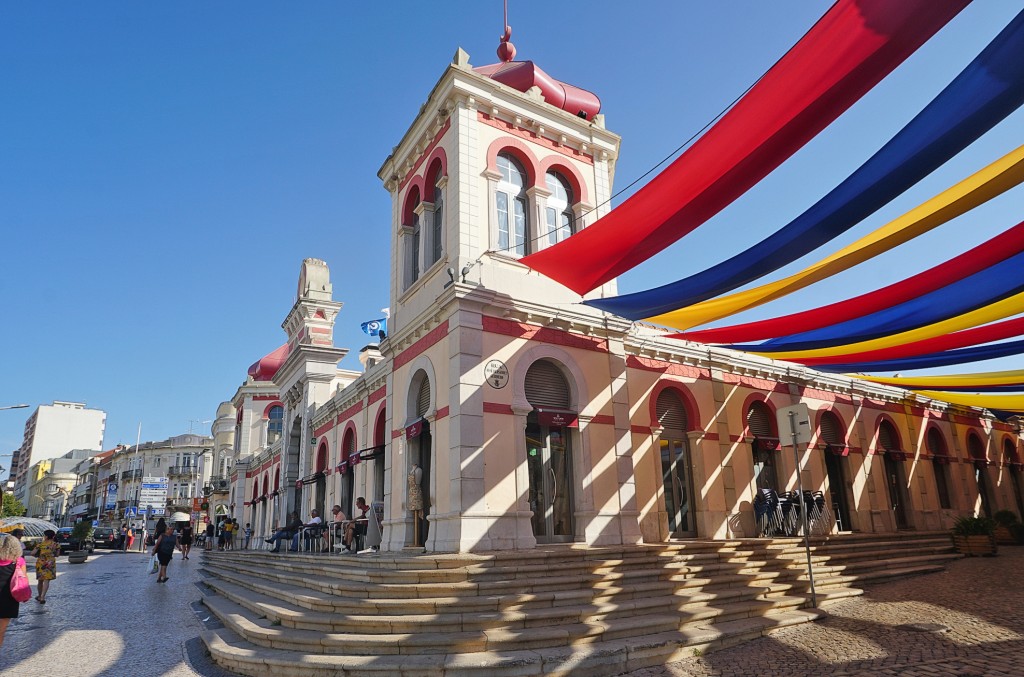Prunkvolles Gebäude mit bunten Fahnen und Treppen vor historischer Promenade